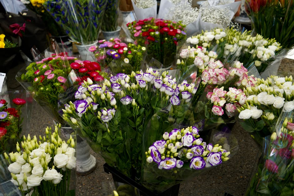 A display of fresh floral bouquets arranged on a table, featuring a variety of colorful flowers including purple and white eustoma, white and pink lisianthus, red and pink daisies, and other blooms wr